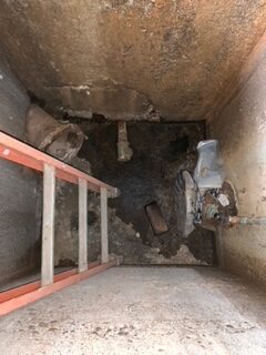 ladder descending into a sewer tank