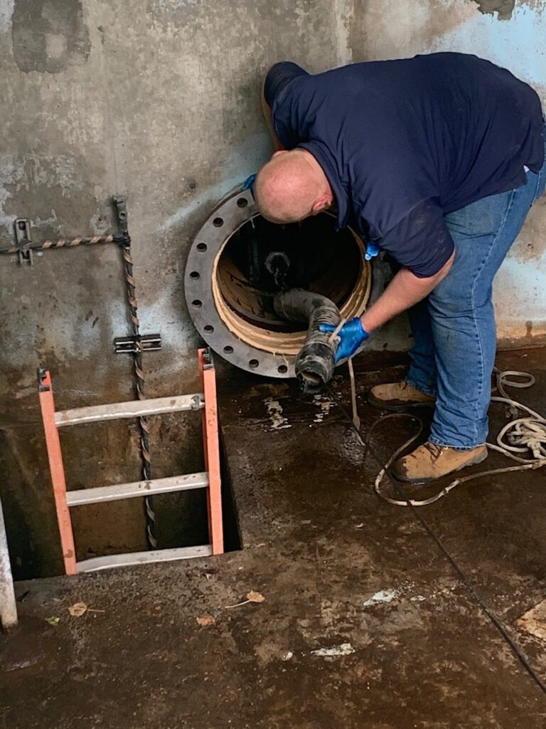 worker clearing out a piping system